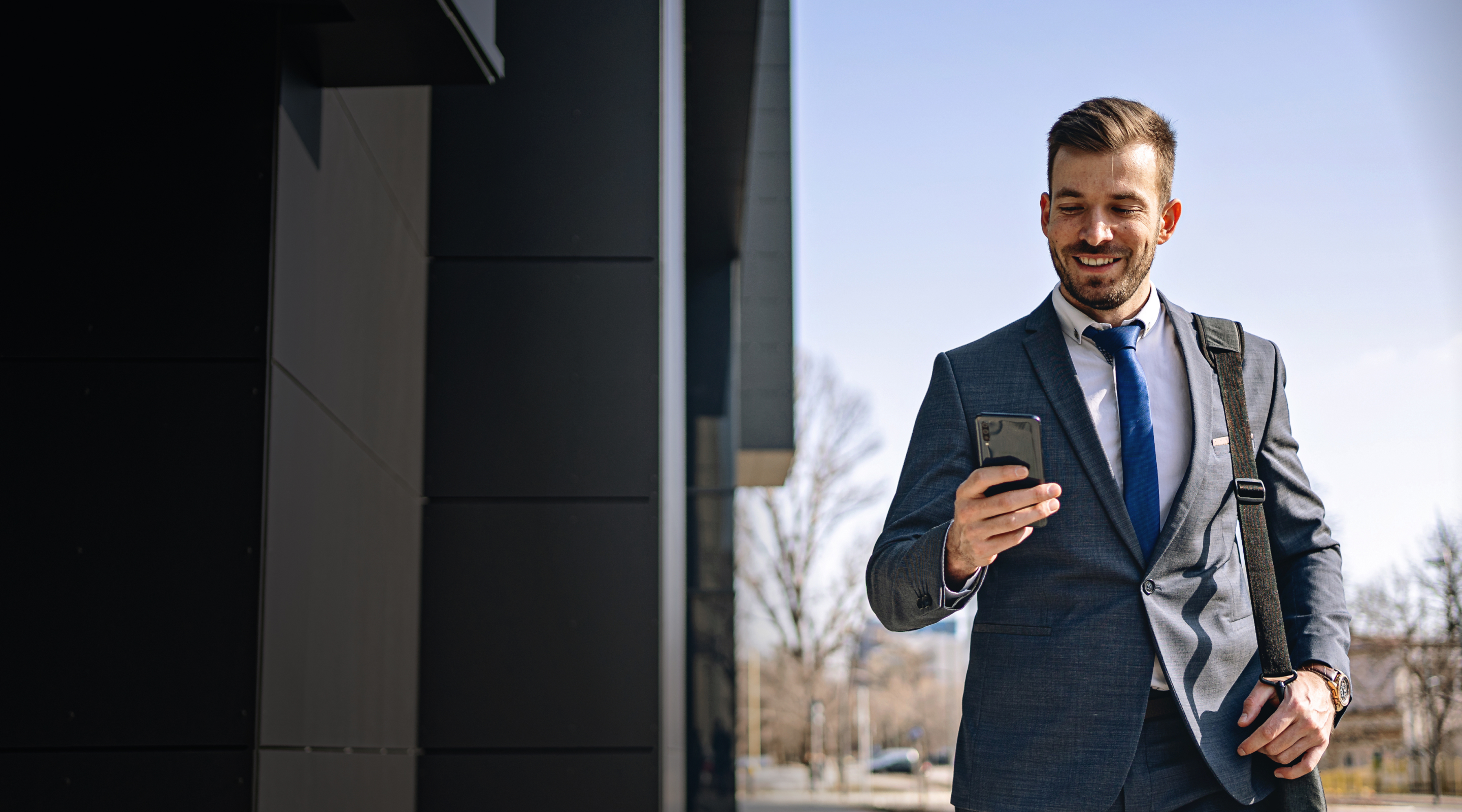 young-male-attorney-checking-messages-walking-to-office-commute