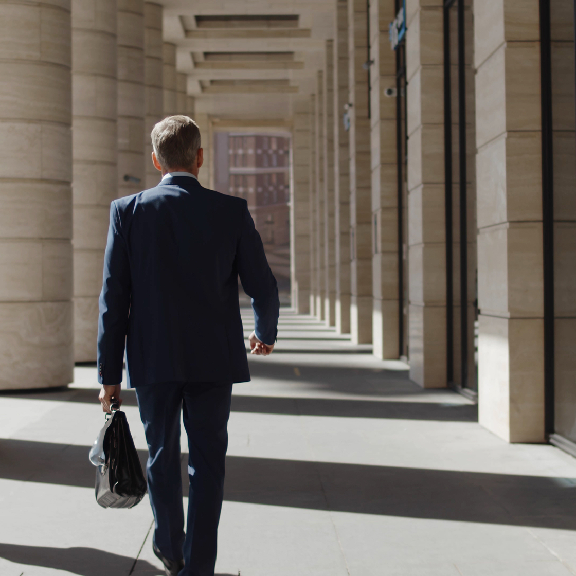 Back view of confident lawyer walking downtown