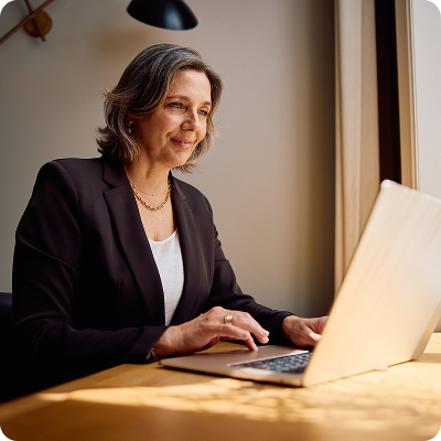 Lawyer smiling while reading a report on her laptop